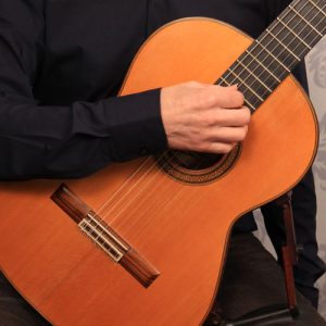playing up by the neck of the guitar