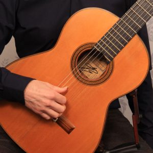 playing by the bridge of the guitar